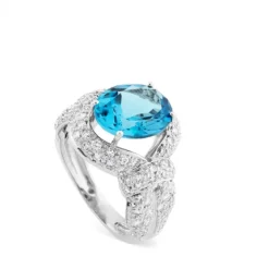 Sortija de oro blanco con topacio azul oval y pavé de diamantes